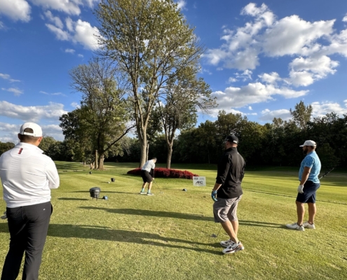 2023 Golf Scramble team hitting the ball