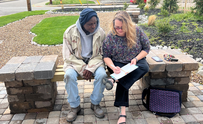 Sarah sitting with client going over paperwork