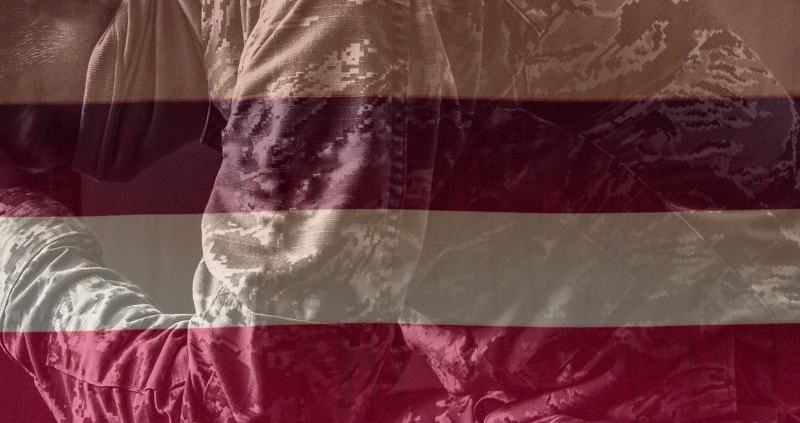 Image of a veteran with an American flag faded in