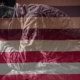 Image of a veteran with an American flag faded in
